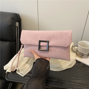 Pink matte suede clutch with leopard embossing and black buckle held by a model
