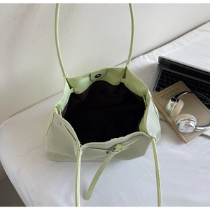 Vue intérieure du sac seau tressé vert menthe avec doublure brune et fermoir aimanté