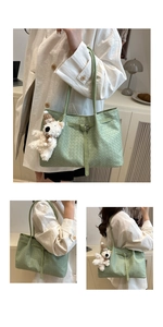 Detail of light green woven tote bag with crossbody strap and cute teddy bear charm