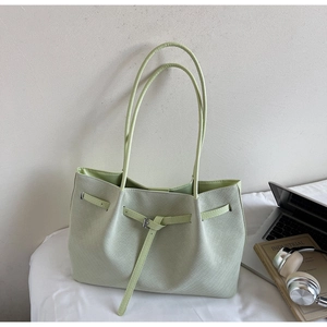 Détail du cabas en cuir PU tissé vert clair avec bandoulière et boucle décorative