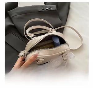 Dettaglio della capacità interna della borsa Boston color crema con decoro in pizzo