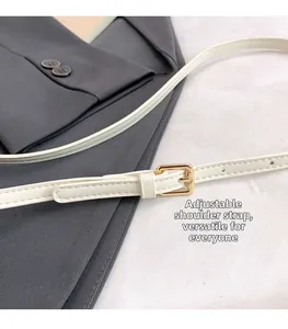 Detail of adjustable white leather strap with elegant gold buckle on a saddle bag
