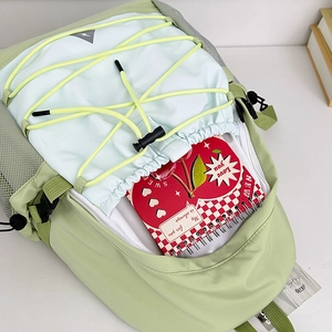 Mint green canvas backpack with yellow cords showing large storage for notebooks
