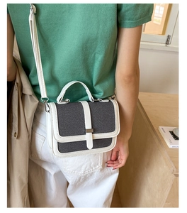 Detail view of stylish color-block small square handbag with textured fabric and PU trim