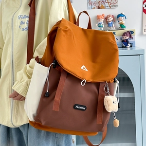Detail view of tri-color Japanese outdoor backpack with plush charm on side pocket