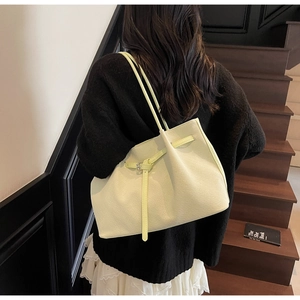 Détail du sac seau jaune citron avec texture tressée et boucle ardillon argentée chic
