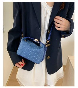 Nahaufnahme der blauen Denim-Umhängetasche mit weißem Muster und Goldbeschlägen