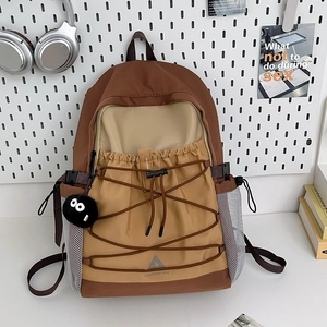 Outdoor canvas backpack with color splicing design and elastic cords on white background