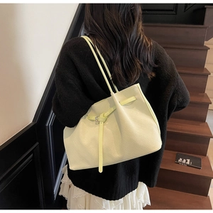 Détail du tissage sur un cabas vert citron avec boucle décorative en situation réelle