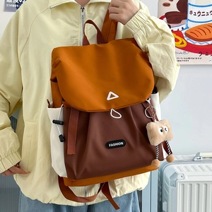 Detail of color-block backpack with drawstring side pocket and plush toast keychain