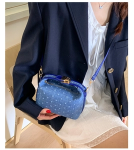 Nahaufnahme der blauen Denim-Umhängetasche mit weißen Punkten und goldenem Vintage-Verschluss