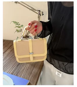 Detail of summer bicolor straw handbag with yellow leather trim and silver metal clasp