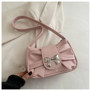 Detail of pink faux leather bag with silver metal bow buckle and pleated design texture