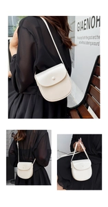 Detail view of a cream minimalist saddle crossbody bag on a model in urban setting