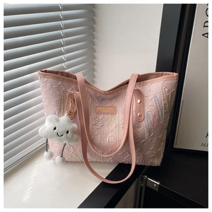 Dettaglio borsa tote rosa con texture 3D, cuciture a onda e ciondolo a nuvola