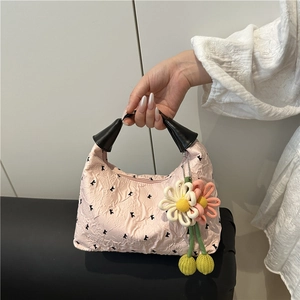 Sac à main plissé rose avec imprimés de lettres noires et breloques de fleurs