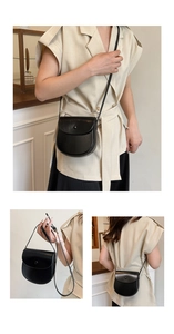 Detail view of black leather saddle bag showing crossbody and handheld styling options
