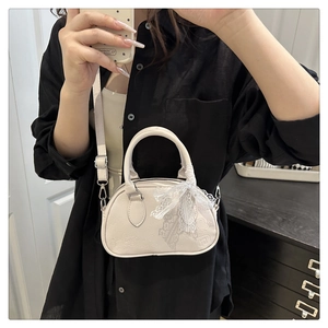 Dettaglio della mini borsa bianca con fiocco in pizzo e motivi a rilievo animati