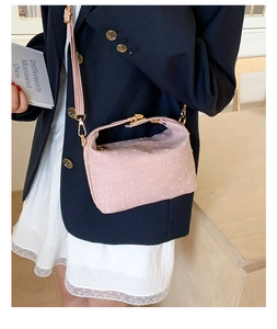 Detail of pink fabric crossbody bag with gold zipper and adjustable metallic buckle