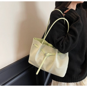Détail du sac cabas tissé vert clair avec boucle à sangle et texture géométrique