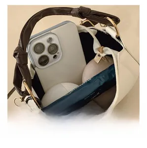 Vue intérieure d'un sac à main crème minimaliste montrant la capacité du téléphone