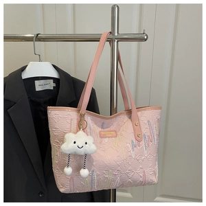 Pink quilted canvas tote bag with embroidered wavy lines and a white cloud plush charm
