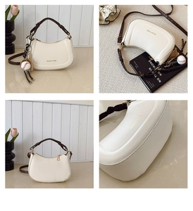 Détail du sac demi-lune blanc cassé en PU avec poignée tressée et pendentif de baseball