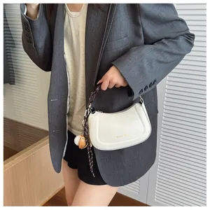 Detail of off-white faux leather hobo bag with Altum! 1988 text and fun character charms