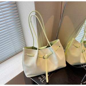 Détail du sac fourre-tout tressé vert pistache avec boucle décorative et fermoir