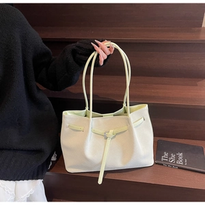 Détail du sac cabas vert clair à texture tissée avec fines lanières et boucles en métal