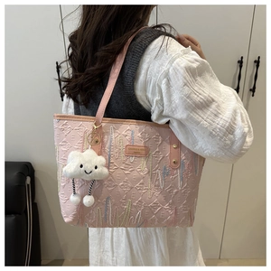 Pink quilted tote bag with wave embroidery and a cute white cloud plush pendant charm