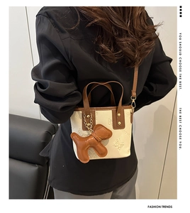 Schicke cremefarbene Mini-Tragetasche mit Hundeanhänger am Model für Büro-Outfits