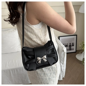 Détail d'un sac à bandoulière en cuir PU noir avec un grand nœud et une boucle argentée