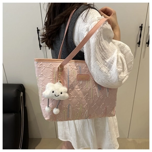 Close-up of pink tote bag featuring embossed E-pattern and wavy line embroidery details
