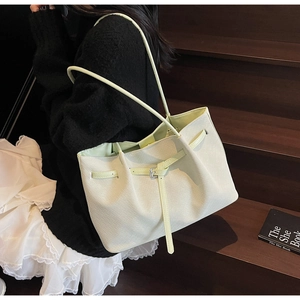 Détail d'un sac cabas tissé vert menthe avec boucle porté par un mannequin