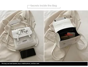 White lace crossbody bag with bow detail showing interior storage for phone and keys