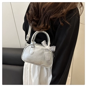 Dettaglio mini borsa argento goffrata con trama metallica, fiocco e manici rotondi