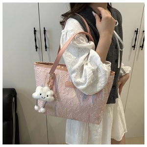 Pink PU tote bag detail with embossed letters, wave stitching and cloud charm accessory