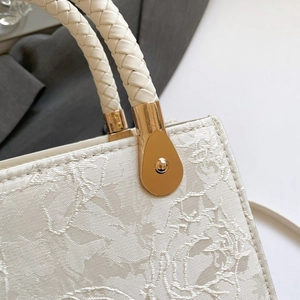 Vintage floral jacquard crossbody bag with woven handle and gold drop-shaped buckle