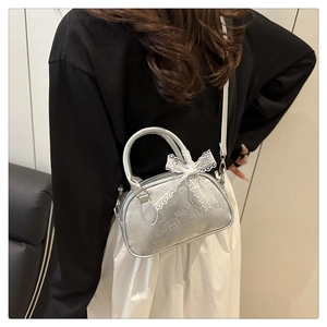 Borsa bowling argento con goffratura graffiti e fiocco di pizzo indossata dalla modella