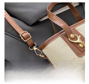 Detail der Handtasche aus Leder mit Lychee-Muster, Gold-Hardware und braunem Gurt