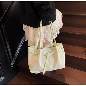 Détail du sac cabas vert clair en similicuir grainé avec une boucle en métal argenté