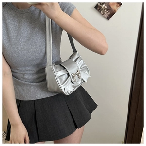 Selfie miroir montrant un sac sous le bras argenté métallisé avec nœud plissé et boucle