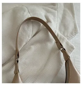 Detail of glossy beige patent leather strap with silver buckle and metal zipper closure