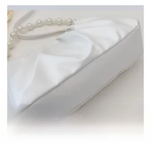 Detailed close-up of white pleated cloud bag with elegant pearl chain strap design
