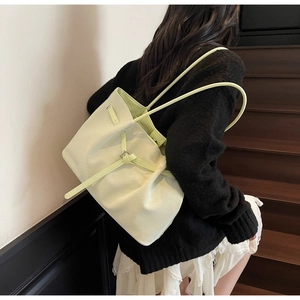 Détail du sac seau vert clair en cuir grainé avec boucle argentée et bandoulière fine