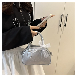 Dettaglio della mini borsa argento con motivo LOVE a rilievo e fiocco in pizzo bianco