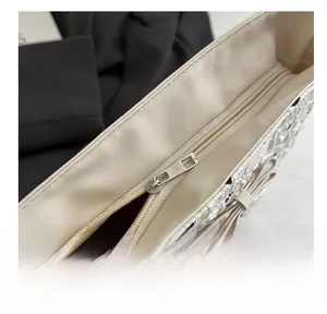 Macro view of silver zipper detail and floral textured fabric on beige bucket bag