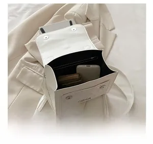 Internal capacity of the cream crossbody bag showing space for wallet and phone