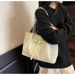 Détail du cabas vert pistache avec texture fine et boucle en métal sur lanière en cuir